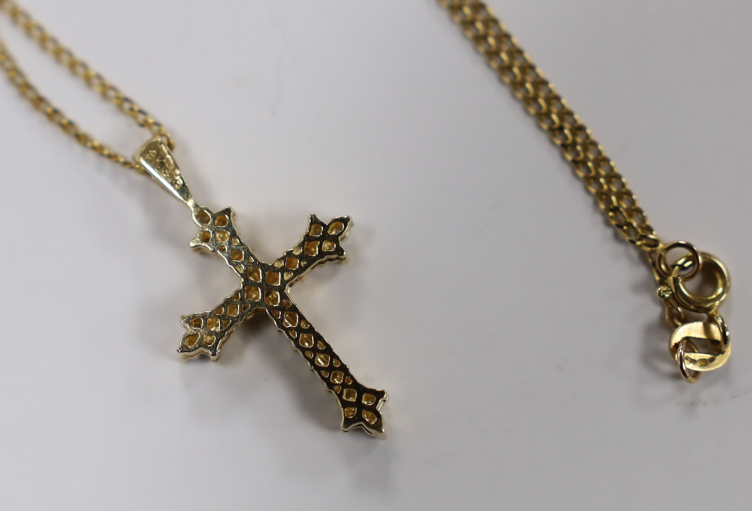 A modern 9ct gold and diamond chip set cross pendant, overall 30mm, on a 9ct gold chain, 40cm, gross weight 4.3 grams.